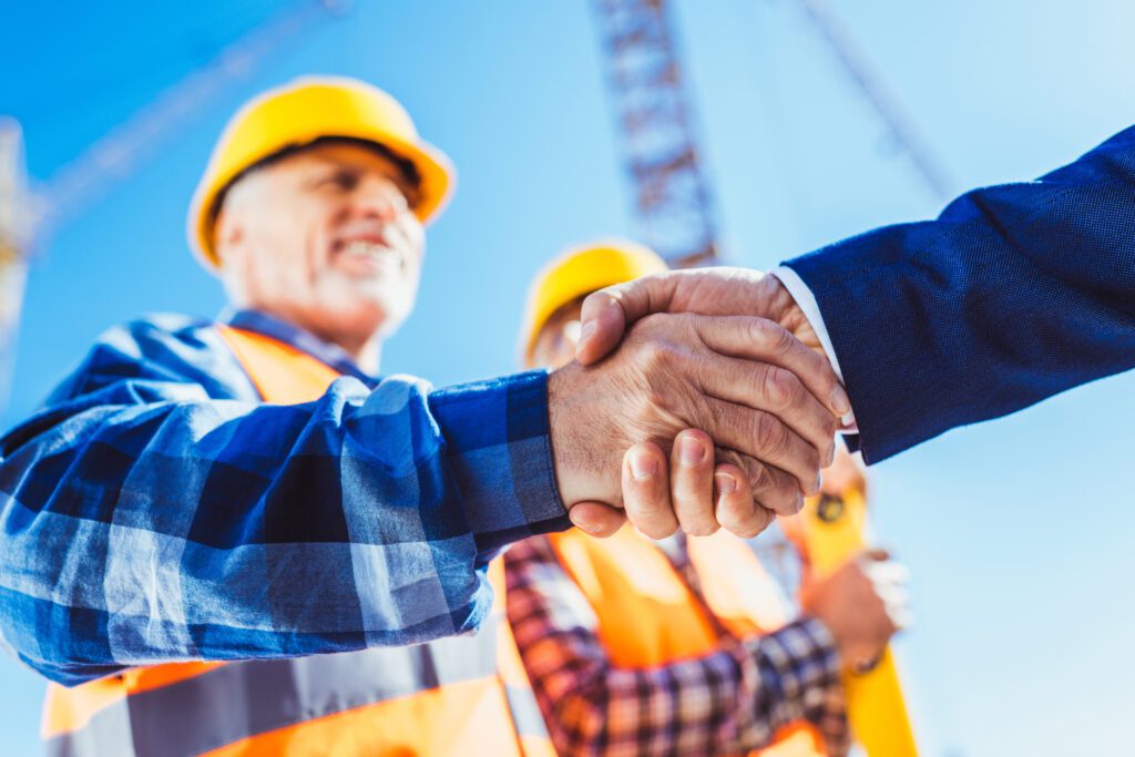 Construction Worker in Protective Uniform Shaking Hand